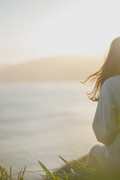 Woman facing the sea, reconnecting with nature